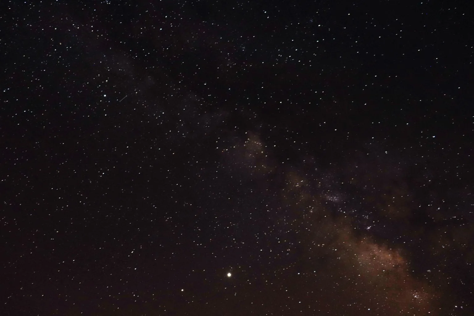 Samanyolu galaksisinin renkli yıldız bulutlarıyla uzandığı yıldız dolu gece göğü